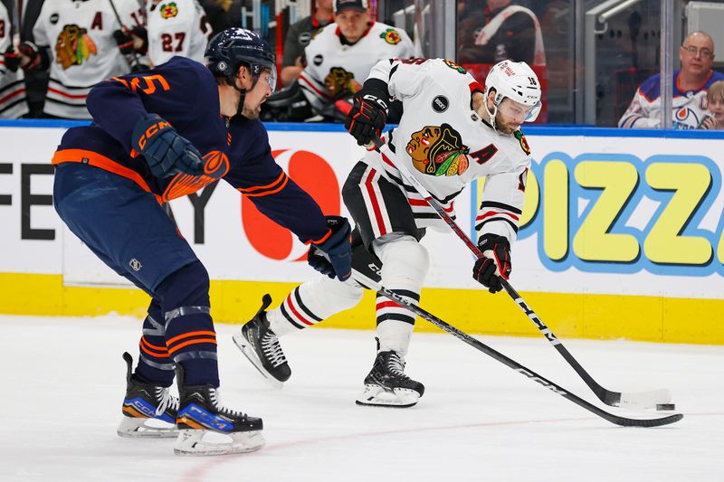 Jan 25, 2024; Edmonton, Alberta, CAN; Chicago Blackhawks forward Jason Dickinson (16) gets a shot away in front of Edmonton Oilers defensemen Cody Ceci (5) during the second period at Rogers Place. Mandatory Credit: Perry Nelson-USA TODAY Sports