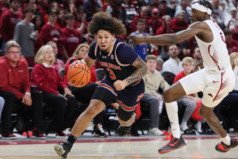 Jan 6, 2024; Fayetteville, Arkansas, USA; Auburn Tigers guard Tre Donaldson (3) drives against Arkansas Razorbacks guard Davonte Davis (4) during the first half at Bud Walton Arena. Mandatory Credit: Nelson Chenault-USA TODAY Sports