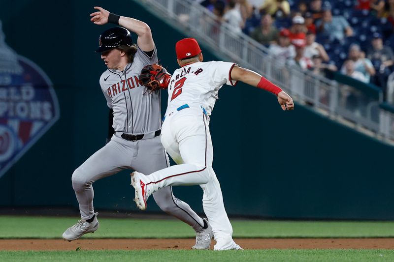 Jun 18, 2024; Washington, District of Columbia, USA; Arizona Diamondbacks outfielder Jake McCarthy (31) is tagged out by Washington Nationals second base Luis García Jr. (2) after being caught in a rundown during the eighth inning at Nationals Park. Mandatory Credit: Geoff Burke-USA TODAY Sports