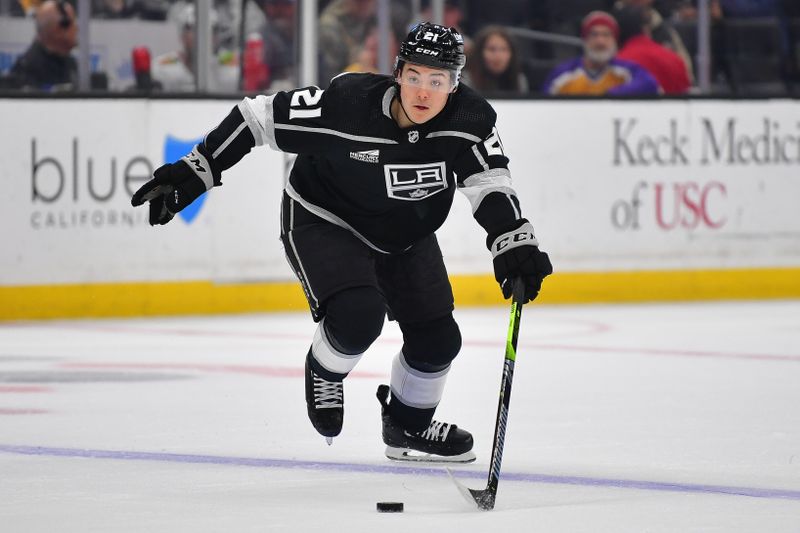 Apr 18, 2024; Los Angeles, California, USA;  Los Angeles Kings defenseman Jordan Spence (21) moves the puck against the Chicago Blackhawks during the second period at Crypto.com Arena. Mandatory Credit: Gary A. Vasquez-USA TODAY Sports