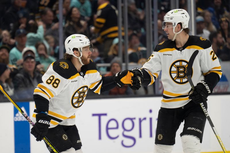 Feb 23, 2023; Seattle, Washington, USA; Boston Bruins forward David Pastrnak (88) is congratulated by defenseman Brandon Carlo (25) after scoring a goal during the second period against the Seattle Kraken at Climate Pledge Arena. Mandatory Credit: Stephen Brashear-USA TODAY Sports