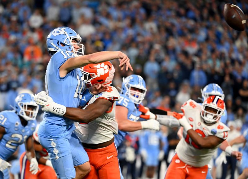 Dec 3, 2022; Charlotte, North Carolina, USA; Clemson Tigers defensive end K.J. Henry (5) hits North Carolina Tar Heels quarterback Drake Maye (10) during the first quarter of the ACC Championship game at Bank of America Stadium. Mandatory Credit: Bob Donnan-USA TODAY Sports