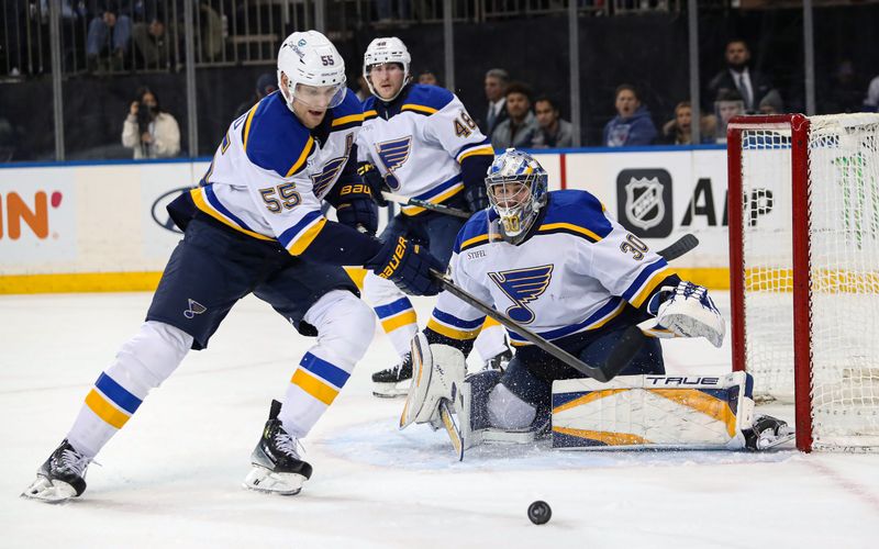 Nov 25, 2024; New York, New York, USA; St. Louis Blues defenseman Colton Parayko (55) plays the puck in front of St. Louis Blues goalie Joel Hofer (30) during the second period against the New York Rangers at Madison Square Garden. Mandatory Credit: Danny Wild-Imagn Images