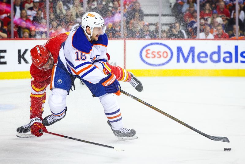 Nov 3, 2024; Calgary, Alberta, CAN; Edmonton Oilers left wing Zach Hyman (18) and Calgary Flames defenseman Kevin Bahl (7) battles for the puck during the first period at Scotiabank Saddledome. Mandatory Credit: Sergei Belski-Imagn Images