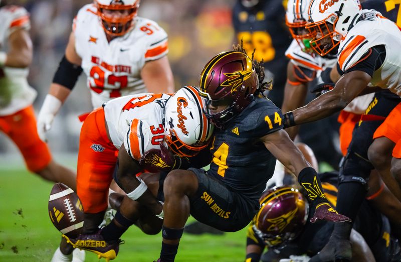 Sep 9, 2023; Tempe, Arizona, USA; Oklahoma State Cowboys linebacker Collin Oliver (30) hits and forces a fumble to Arizona State Sun Devils running back Kyson Brown (14) in the first half at Mountain America Stadium. Mandatory Credit: Mark J. Rebilas-USA TODAY Sports