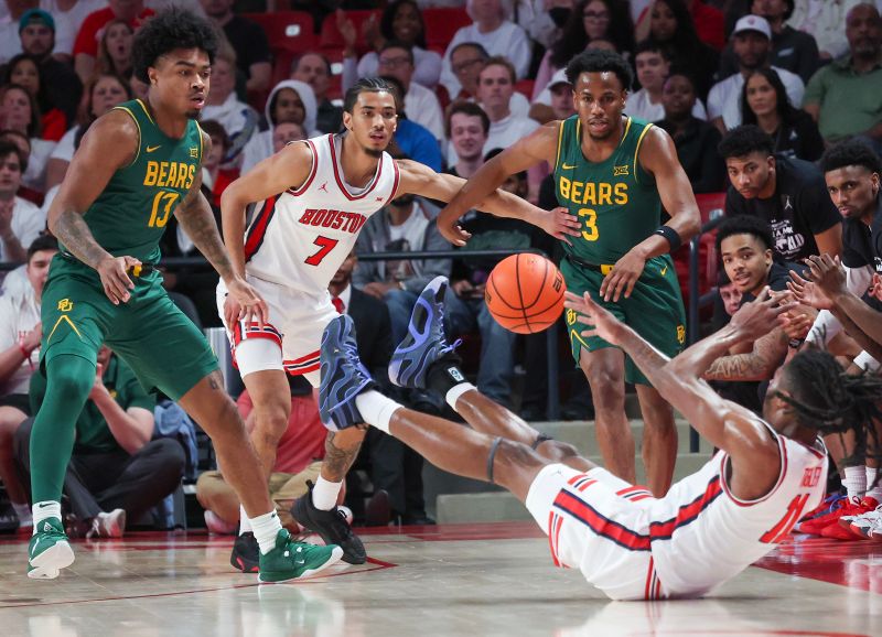 Feb 10, 2025; Houston, Texas, USA; Houston Cougars forward Joseph Tugler (11) passes to guard Milos Uzan (7) why Baylor Bears guard Langston Love (13) and guard Jeremy Roach (3) defend in the first half  at Fertitta Center. Mandatory Credit: Thomas Shea-Imagn Images