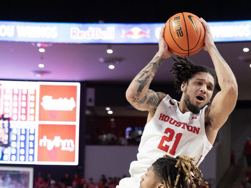 Jan 6, 2024; Houston, Texas, USA; Houston Cougars guard Emanuel Sharp (21) shoots against West Virginia Mountaineers guard Noah Farrakhan (1) in the second half at Fertitta Center. Mandatory Credit: Thomas Shea-USA TODAY Sports