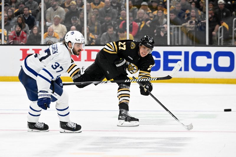 Apr 22, 2024; Boston, Massachusetts, USA; Boston Bruins defenseman Hampus Lindholm (27) passes the puck against Toronto Maple Leafs defenseman Timothy Liljegren (37) during the third period in game two of the first round of the 2024 Stanley Cup Playoffs at TD Garden. Mandatory Credit: Brian Fluharty-USA TODAY Sports