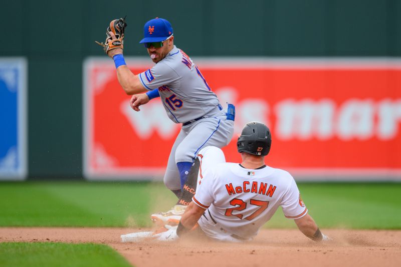 Aug 6, 2023; Baltimore, Maryland, USA; Baltimore Orioles catcher James McCann (27) reaches second base safely before the tag by New York Mets shortstop Danny Mendick (15) during the seventh inning at Oriole Park at Camden Yards. Mandatory Credit: Reggie Hildred-USA TODAY Sports