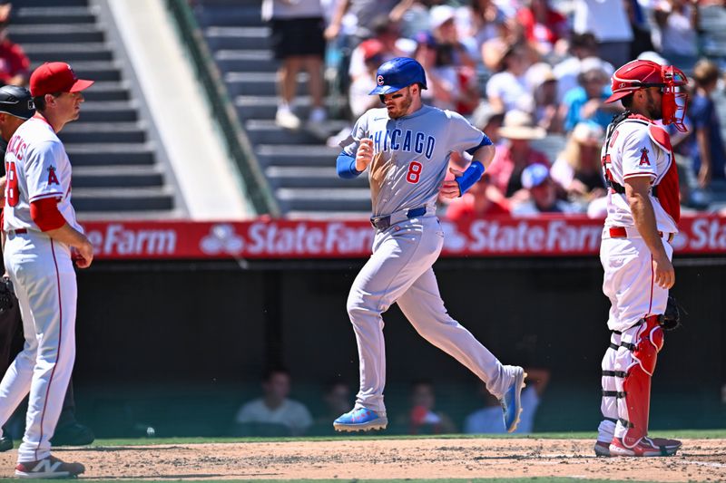 Aug 24, 2025; Anaheim, California, USA; Chicago Cubs outfielder Ian Happ (8) runs to home plate against Los Angeles Angels catcher Travis d'Arnaud (25) and starting pitcher Kyle Hendricks (28) during the fourth inning at Angel Stadium. Mandatory Credit: Jonathan Hui-Imagn Images