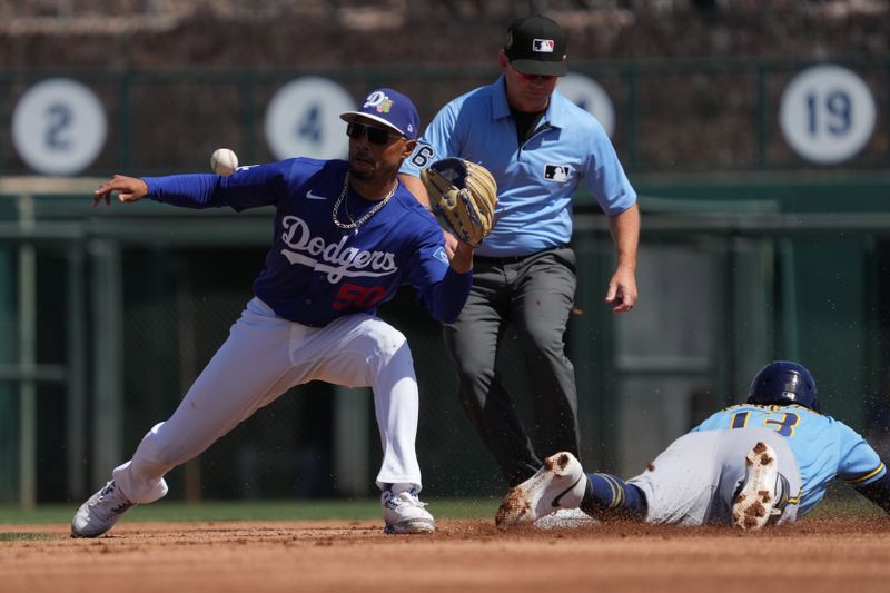 Mar 16, 2026; Phoenix, Arizona, USA; Milwaukee Brewers third baseman Luis Rengifo (13) steals second base under the throw to Los Angeles Dodgers shortstop Mookie Betts (50) in the first inning at Camelback Ranch-Glendale. Mandatory Credit: Rick Scuteri-Imagn Images