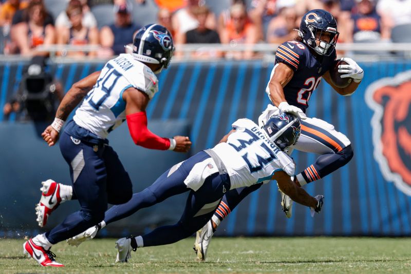 Chicago Bears running back Travis Homer (20) is tackled by Tennessee Titans cornerback Eric Garror (33) during the second half of an NFL preseason football game, Saturday, Aug. 12, 2023, in Chicago. (AP Photo/Kamil Krzaczynski)