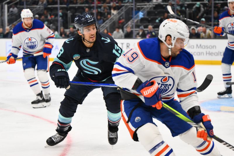 Oct 2, 2024; Seattle, Washington, USA; Seattle Kraken left wing Brandon Tanev (13) plays defense on Edmonton Oilers center Adam Henrique (19) during the third period at Climate Pledge Arena. Mandatory Credit: Steven Bisig-Imagn Images