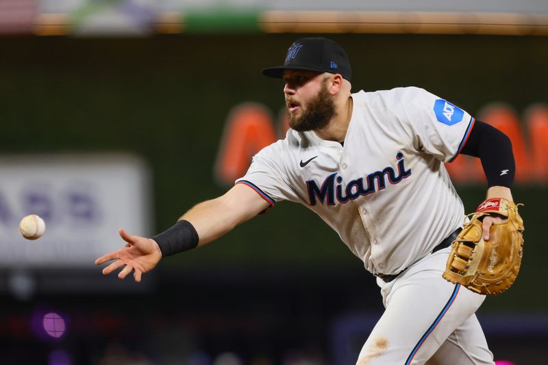 Aug 19, 2024; Miami, Florida, USA; Miami Marlins first baseman Jake Burger (36) tosses the baseball to relief pitcher Kent Emanuel (not pictured) to retire Arizona Diamondbacks right fielder Corbin Carroll (not pictured) during the sixth inning at loanDepot Park. Mandatory Credit: Sam Navarro-USA TODAY Sports