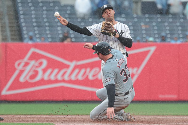 May 5, 2024; Bronx, New York, USA; New York Yankees shortstop Anthony Volpe (11) attempts to turn a double play after forcing out Detroit Tigers second baseman Colt Keith (33) at second base during the seventh inning at Yankee Stadium. Mandatory Credit: Vincent Carchietta-USA TODAY Sports