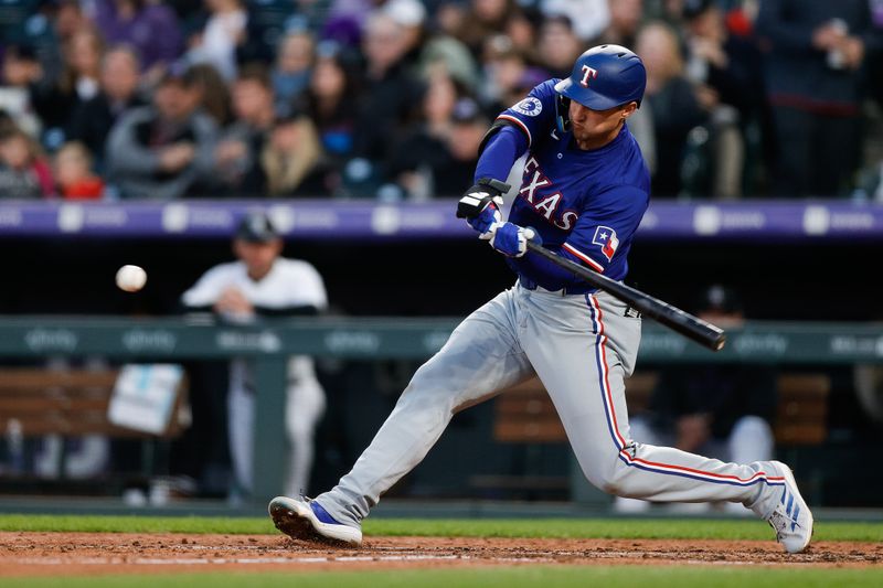 May 10, 2024; Denver, Colorado, USA; Texas Rangers shortstop Corey Seager (5) hits a solo home run in the sixth inning against the Colorado Rockies at Coors Field. Mandatory Credit: Isaiah J. Downing-USA TODAY Sports