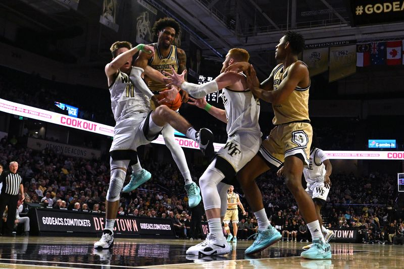 Feb 11, 2023; Winston-Salem, North Carolina, USA; Georgia Tech Yellow Jackets forward Javon Franklin (4) battles with Wake Forest Demon Deacons forward Andrew Carr (11) and guard Cameron Hildreth (2) for the ball during the second half at Lawrence Joel Veterans Memorial Coliseum. Mandatory Credit: William Howard-USA TODAY Sports