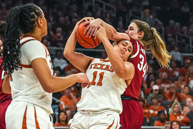 Jan 5, 2025; Austin, Texas, USA; Arkansas forward Jenna Lawrence (34) and Texas Longhorns forward Justice Carlton (11) fight for a rebound during the game at Moody Center. Mandatory Credit: Aaron E. Martinez/USA TODAY Network via Imagn Images