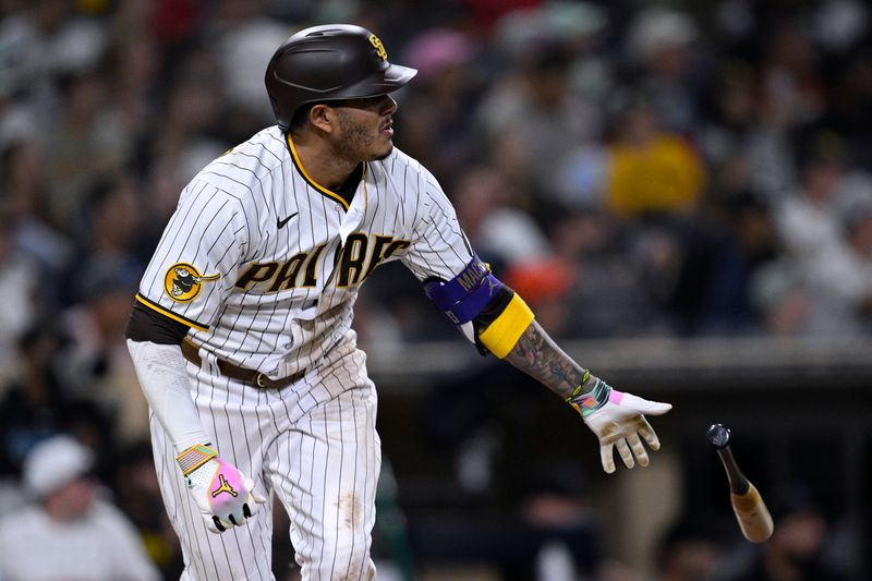 Aug 21, 2023; San Diego, California, USA; San Diego Padres third baseman Manny Machado (13) hits a home run against the Miami Marlins during the fifth inning at Petco Park. Mandatory Credit: Orlando Ramirez-USA TODAY Sports