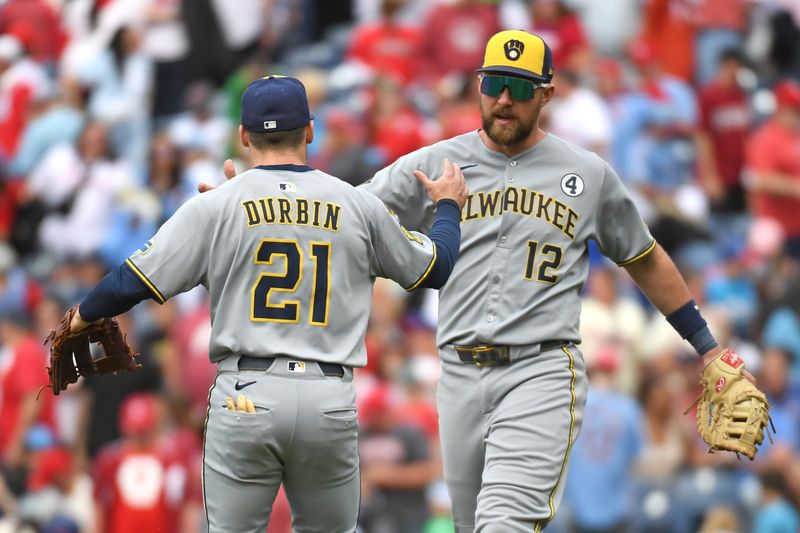 Jun 1, 2025; Philadelphia, Pennsylvania, USA; Milwaukee Brewers third base Caleb Durbin (21) and first base Rhys Hoskins (12) celebrate win against the Philadelphia Phillies at Citizens Bank Park. Mandatory Credit: Eric Hartline-Imagn Images