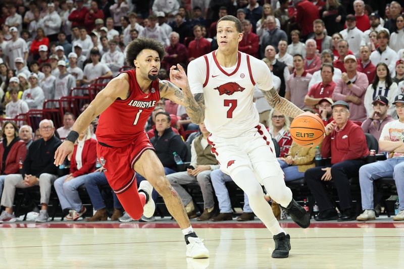 Dec 3, 2025; Fayetteville, Arkansas, USA; Arkansas Razorbacks forward Trevon Brazile (7) drives to the basket as Louisville Cardinals guard J’Vonne Hadley (1) defends during the first half at Bud Walton Arena. Mandatory Credit: Nelson Chenault-Imagn Images