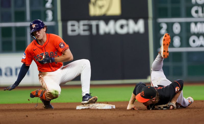 Jun 21, 2024; Houston, Texas, USA; Baltimore Orioles shortstop Gunnar Henderson (2) can’t handle the throw as Houston Astros left fielder Joey Loperfido (10) is safe on a RBI double in the sixth inning at Minute Maid Park. Mandatory Credit: Thomas Shea-USA TODAY Sports