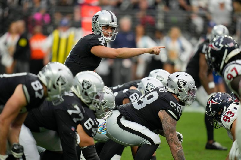 Las Vegas Raiders quarterback Derek Carr motions during the first half of an NFL football game against the Houston Texans, Sunday, Oct. 23, 2022, in Las Vegas. (AP Photo/John Locher)