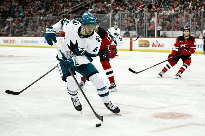 Nov 10, 2024; Newark, New Jersey, USA; San Jose Sharks center Alexander Wennberg (21) skates past New Jersey Devils center Nico Hischier (13) during the third period at Prudential Center. Mandatory Credit: John Jones-Imagn Images