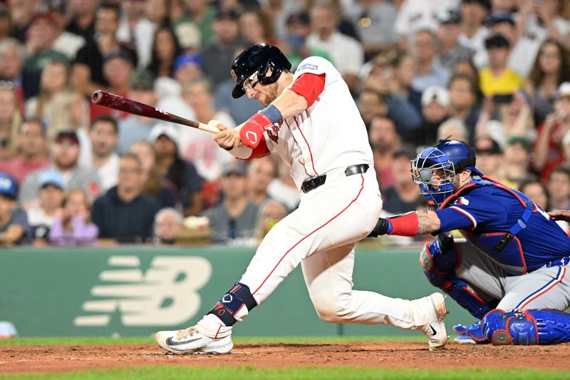 Aug 14, 2024; Boston, Massachusetts, USA; Boston Red Sox catcher Danny Jansen (28) hits a RBI single against the Texas Rangers during the eighth inning at Fenway Park. Mandatory Credit: Brian Fluharty-USA TODAY Sports