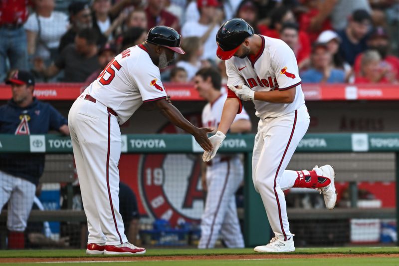 Jul 27, 2024; Anaheim, California, USA; Los Angeles Angels first baseman Nolan Schanuel (18) celebrates with third base coach Eric Young Sr. (85) after hitting a home run against the Oakland Athletics during the third inning at Angel Stadium. Mandatory Credit: Jonathan Hui-USA TODAY Sports