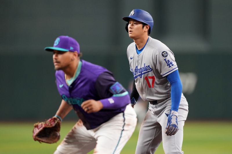 May 10, 2025; Phoenix, Arizona, USA; Los Angeles Dodgers two-way player Shohei Ohtani (17) leads off first base as Arizona Diamondbacks first base Josh Naylor (22) covers the bag during the first inning at Chase Field. Mandatory Credit: Joe Camporeale-Imagn Images