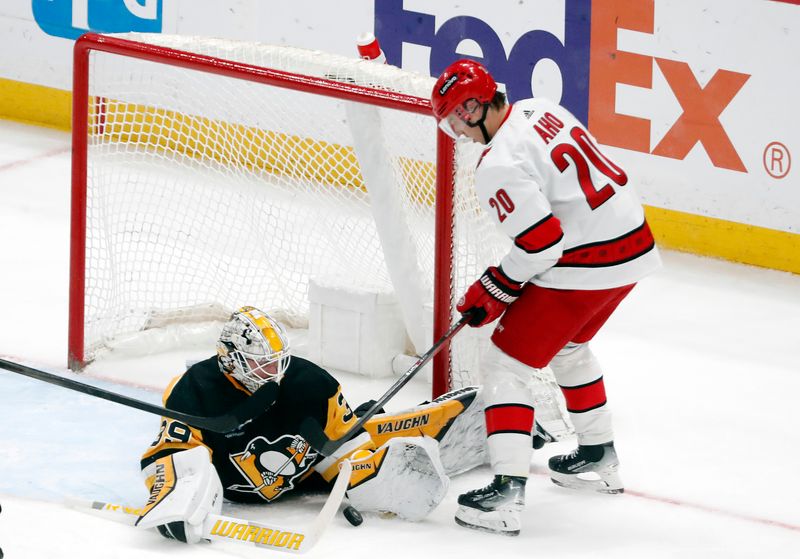 Mar 26, 2024; Pittsburgh, Pennsylvania, USA; Pittsburgh Penguins goaltender Alex Nedeljkovic (39) makes a save as Carolina Hurricanes center Sebastian Aho (20) looks for a rebound during the second period at PPG Paints Arena. Mandatory Credit: Charles LeClaire-USA TODAY Sports