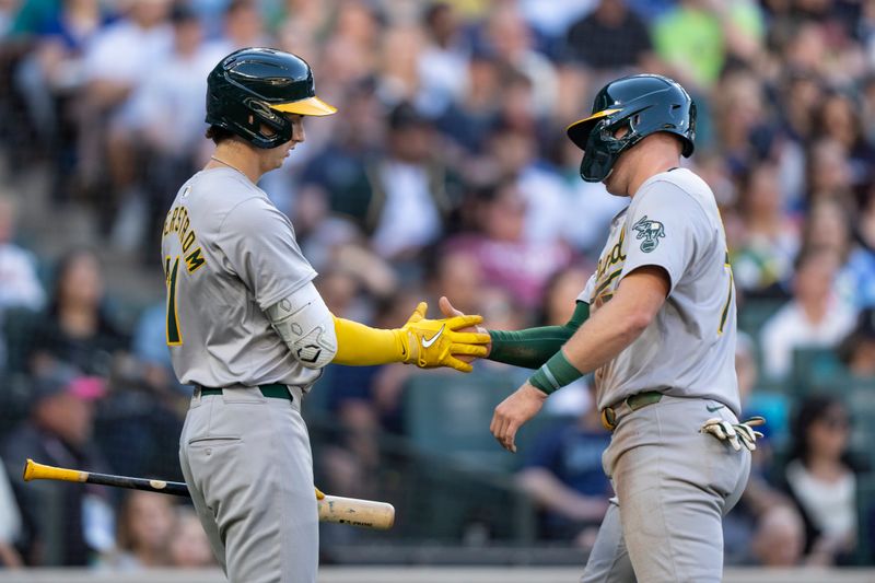 May 11, 2024; Seattle, Washington, USA; Oakland Athletics third baseman Brett Harris (77) is congratulated by first baseman Tyler Soderstrom (21) after scoring a run during the third inning against the Seattle Mariners at T-Mobile Park. Mandatory Credit: Stephen Brashear-USA TODAY Sports