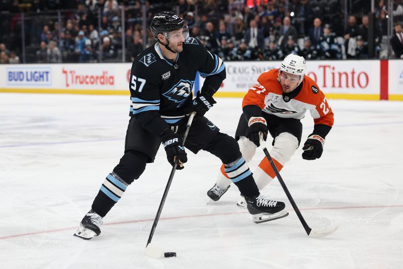 Jan 21, 2026; Salt Lake City, Utah, USA; Utah Mammoth defenseman Nick DeSimone (57) skates with the puck against Philadelphia Flyers left wing Noah Cates (27) during the first period at Delta Center. Mandatory Credit: Rob Gray-Imagn Images