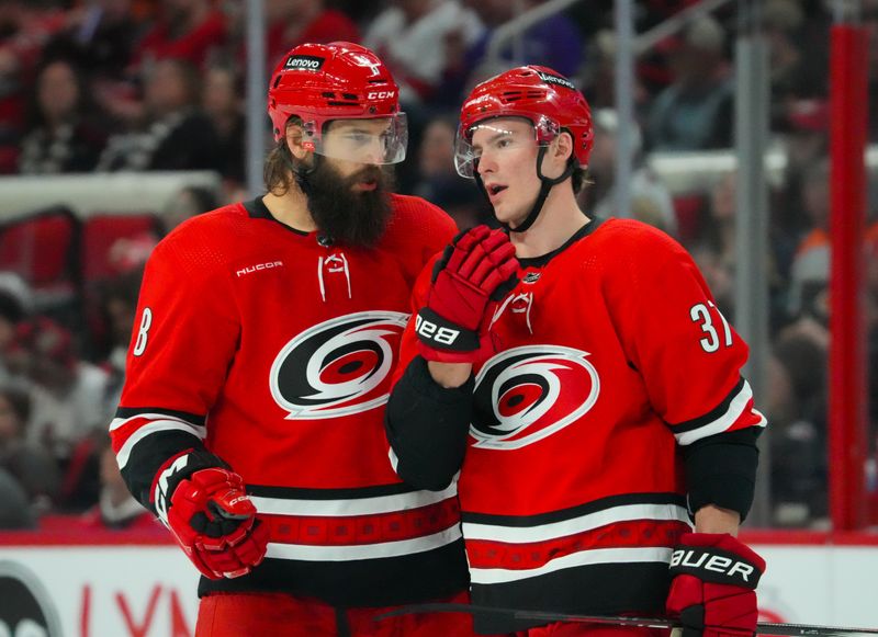 Mar 21, 2024; Raleigh, North Carolina, USA; Carolina Hurricanes defenseman Brent Burns (8) and right wing Andrei Svechnikov (37) talk against the Philadelphia Flyers during the first period at PNC Arena. Mandatory Credit: James Guillory-USA TODAY Sports