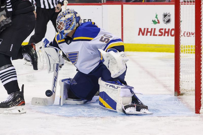 Nov 27, 2024; Newark, New Jersey, USA; St. Louis Blues goaltender Jordan Binnington (50) makes a save against the New Jersey Devils during the second period at Prudential Center. Mandatory Credit: Ed Mulholland-Imagn Images