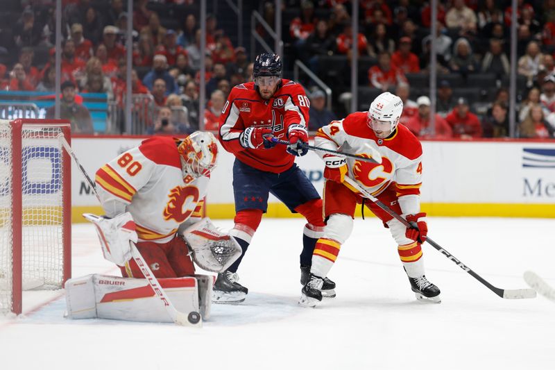 Feb 25, 2025; Washington, District of Columbia, USA; Calgary Flames goaltender Dan Vladar (80) makes a save in front of Washington Capitals left wing Pierre-Luc Dubois (80) and Flames defenseman Joel Hanley (44) in the third period at Capital One Arena. Mandatory Credit: Geoff Burke-Imagn Images