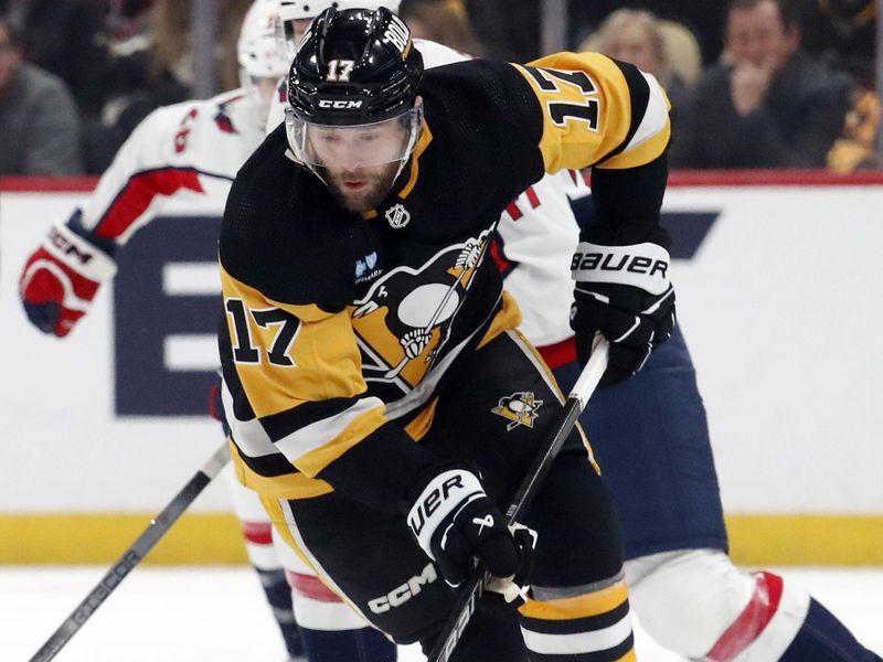 Jan 2, 2024; Pittsburgh, Pennsylvania, USA;  Pittsburgh Penguins right wing Bryan Rust (17) moves the puck against the Washington Capitals during the first period at PPG Paints Arena. Mandatory Credit: Charles LeClaire-USA TODAY Sports