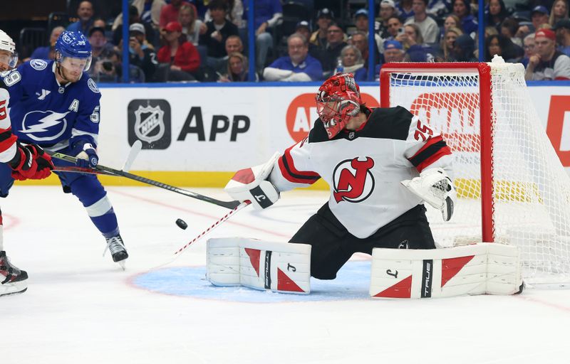 Nov 18, 2025; Tampa, Florida, USA; New Jersey Devils goaltender Jacob Markstrom (25) defends the puck against the Tampa Bay Lightning  during the third period at Benchmark International Arena. Mandatory Credit: Kim Klement Neitzel-Imagn Images