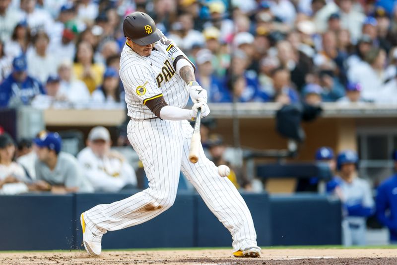 Jun 9, 2025; San Diego, California, USA; San Diego Padres third baseman Manny Machado (13) hits a rbi double during the first inning against the Los Angeles Dodgers at Petco Park. Mandatory Credit: David Frerker-Imagn Images