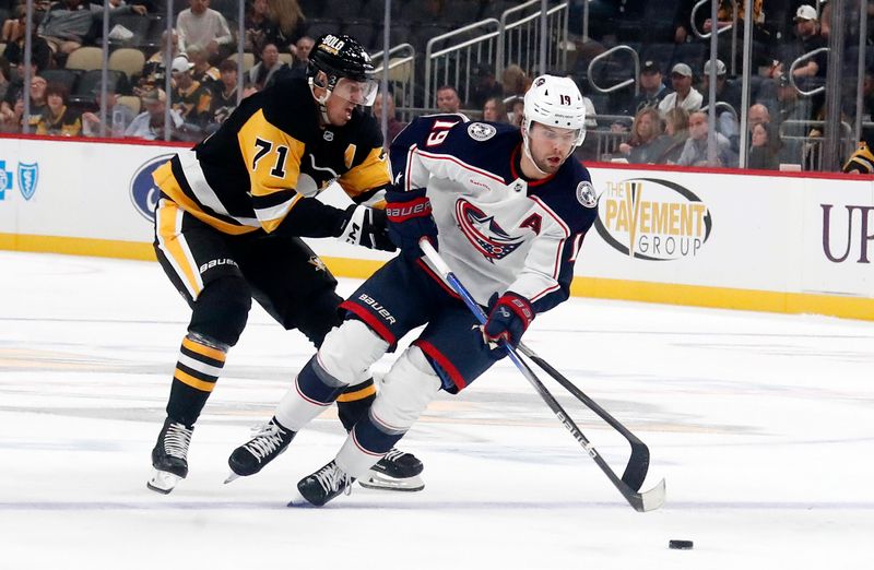 Oct 4, 2024; Pittsburgh, Pennsylvania, USA;  Columbus Blue Jackets center Adam Fantilli (19) skates up ice with the puck ahead of Pittsburgh Penguins center Evgeni Malkin (71) during the second period at PPG Paints Arena. Mandatory Credit: Charles LeClaire-Imagn Images