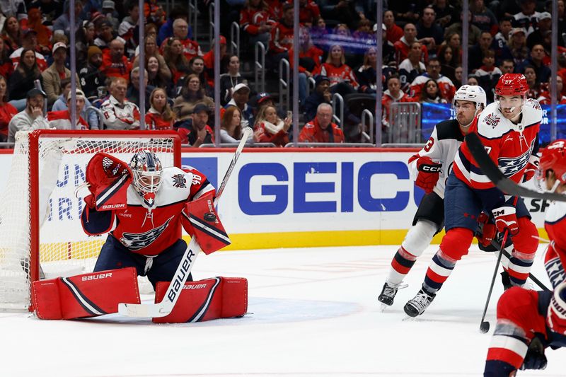 Nov 15, 2025; Washington, District of Columbia, USA; Washington Capitals goaltender Logan Thompson (48) makes a save as New Jersey Devils center Nico Hischier (13) and Capitals defenseman Trevor van Riemsdyk (57) during the second period at Capital One Arena. Mandatory Credit: Geoff Burke-Imagn Images