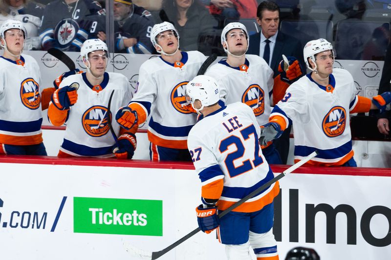 Jan 16, 2024; Winnipeg, Manitoba, CAN; New York Islanders forward Anders Lee (27) is congratulated by his team mates on his goal against the Winnipeg Jets during the third period at Canada Life Centre. Mandatory Credit: Terrence Lee-USA TODAY Sports