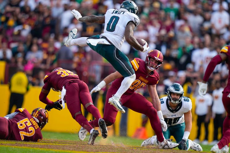 Philadelphia Eagles running back D'Andre Swift (0) leaping over Washington Commanders safety Percy Butler (35) during the second half of an NFL football game, Sunday, Oct. 29, 2023, in Landover, Md. (AP Photo/Alex Brandon)