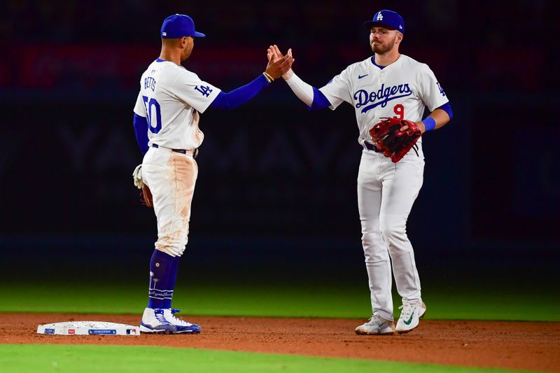 May 4, 2024; Los Angeles, California, USA; Los Angeles Dodgers second baseman Gavin Lux (9) and shortstop Mookie Betts (50) celebrate the victory against the Atlanta Braves at Dodger Stadium. Mandatory Credit: Gary A. Vasquez-USA TODAY Sports