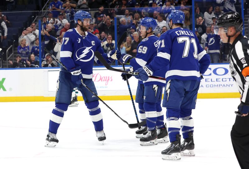 Dec 5, 2024; Tampa, Florida, USA; Tampa Bay Lightning center Jake Guentzel (59) is congratulated by defenseman Victor Hedman (77), center Anthony Cirelli (71) and teammates after he scored a goal against the San Jose Sharks during the first period at Amalie Arena. Mandatory Credit: Kim Klement Neitzel-Imagn Images