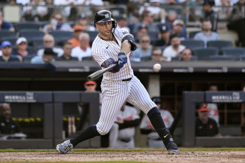 Jun 20, 2024; Bronx, New York, USA; New York Yankees designated hitter Giancarlo Stanton (27) hits a single during the fifth inning against the Baltimore Orioles at Yankee Stadium. Mandatory Credit: John Jones-USA TODAY Sports