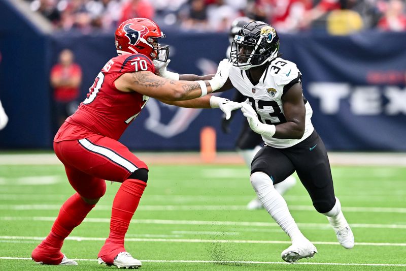 Jacksonville Jaguars linebacker Devin Lloyd (33) and Houston Texans center Juice Scruggs (70) in action during an NFL football game, Sunday, Nov. 26, 2023, in Houston (AP Photo/Maria Lysaker)
