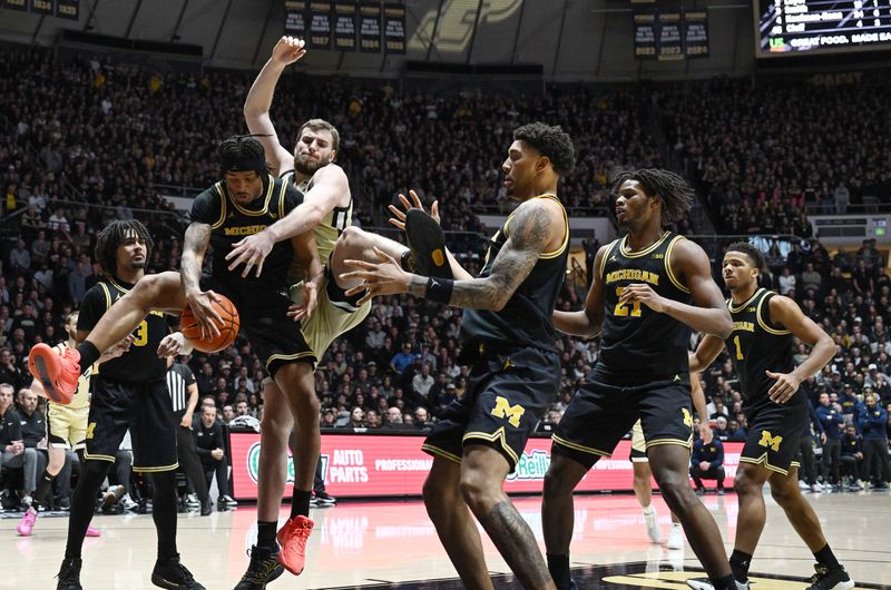 Feb 17, 2026; West Lafayette, Indiana, USA; Purdue Boilermakers center Oscar Cluff (45) goes after a rebound surrounded by Michigan Wolverines during the second half at Mackey Arena. Mandatory Credit: Marc Lebryk-Imagn Images