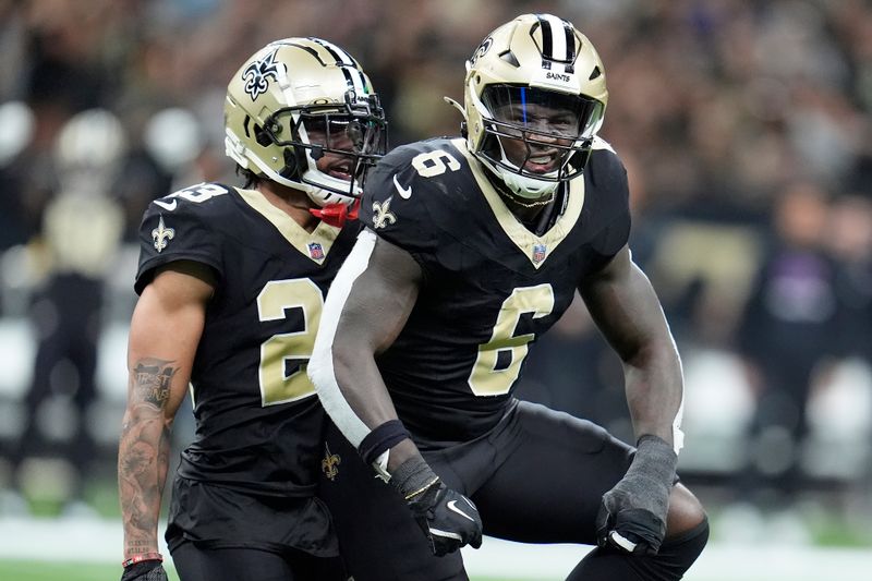 New Orleans Saints linebacker Willie Gay Jr. (6) celebrates next to cornerback Marshon Lattimore after sacking Tampa Bay Buccaneers quarterback Baker Mayfield during the second half of an NFL football game in New Orleans, Sunday, Oct. 13, 2024. (AP Photo/Michael Conroy)